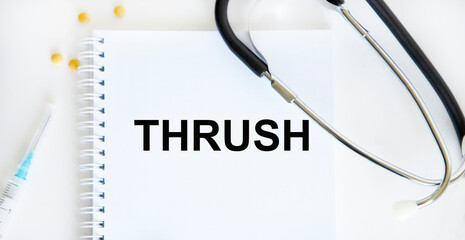 In the notebook THRUSH tets, next to a stetscop and syringe, tablets.
