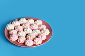 Sugar protein dessert in pastel colors in a pink plate on blue background
