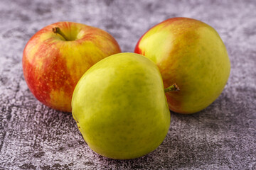 Green and red apples on blackboard or chalkboard background. Close-up on a gray background.Ideal food for diet.
