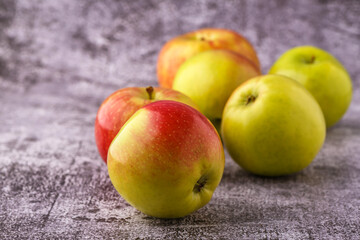Green and red apples on blackboard or chalkboard background. Close-up on a gray background.Ideal food for diet.
