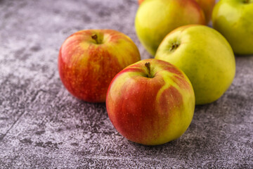 Green and red apples on blackboard or chalkboard background. Close-up on a gray background.Ideal food for diet.