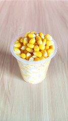 corn in a bowl.steamed corn in a cup on a wooden table.