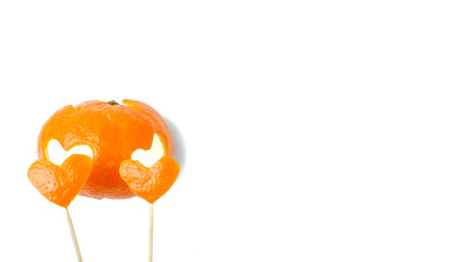 Mandarin peel on a white background with carved hearts on wooden sticks