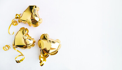 Three gold hearts, foil balloons top view on white background. Valentine's day, banner, postcard.