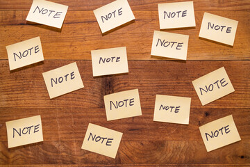 Group of sticky notes on a rustic wooden wall background. Note message on yellow post it paper wallpaper. Notepaper labels on message board