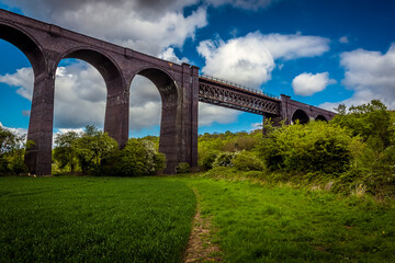 Fototapeta premium A path leads underneath the Conisbrough Viaduct as it crosses over the River Don at Conisbrough, Yorkshire, UK in springtime