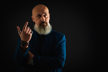 Smiling business man with beard showing man, gesturing with hands, showing something, isolated on dark background. Low key. The portrait is emotional