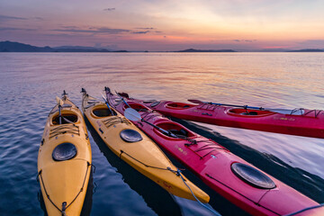 Komodo,Indonesia:November 12,2019: colorful Kayaks bound together on the ocean  at sunset