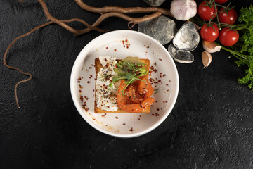 Toast with salmon, avocado and cream cheese. Cold breakfast of fish, vegetables, toasted bread and spiced cream cheese.