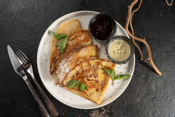 Crepe with berry sauce, mint and chia seeds. Classic hot breakfast. Pancakes made from eggs and flour. A traditional dish of Maslenitsa.