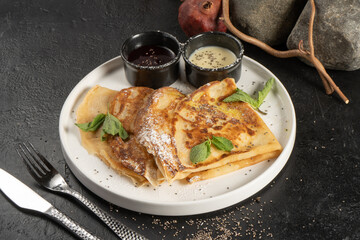 Crepe with berry sauce, mint and chia seeds. Classic hot breakfast. Pancakes made from eggs and flour. A traditional dish of Maslenitsa.