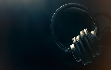 Black professional headphones on a black background. Musical production. Sound studio equipment....