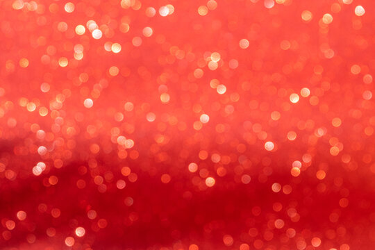 Celebration and special event concept: Blurry and shimmering red background with copy space. Glowing luxury texture with bokeh effect taken by photo camera.