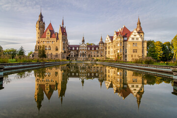 Bajkowy Zamek w Mosznej, lustrzane odbicie w wodzie o wschodzie słońca - obrazy, fototapety, plakaty