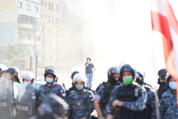 protestors rioting in the street of beirut lebanon during the day, being confronted by the riot...