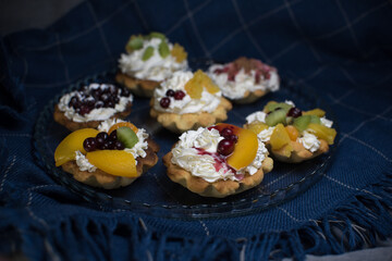 dessert with cream and fruit in tartlets on blue