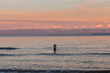 Uomo che fa il bagno al mare a novembre, alla luce di un tramonto francese