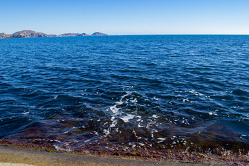 View of the blue sea with small waves against the blue sky. 