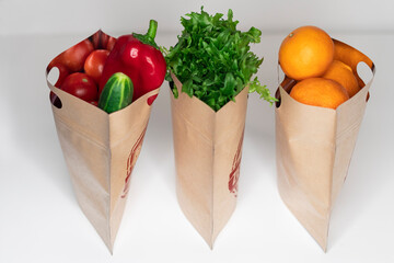 Fresh natural vegetables and tangerines in paper bags for storage with a zipper. Reusable packaging without plastic, zero west concept.