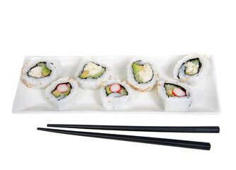 Close up top view of California rolls and crab roll sushi on a large rectangular porcelain plate with black chop sticks. Isolated on white