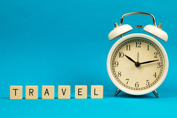 Template with word travel and alarm clock, composition on blue isolated background with copy space