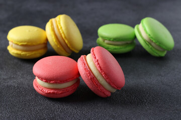 Colorful french macaroons on dark grey background. Closeup. Horizontal format