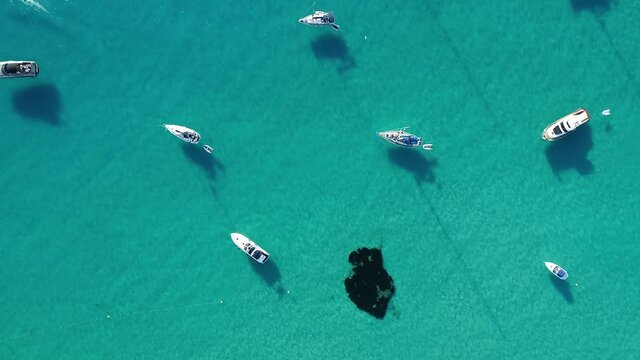 Formentera footage, aerial shot traveling with drone of boats anchored in turquoise sea