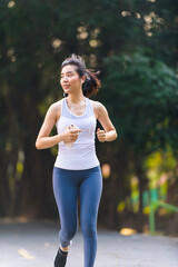 Fototapeta premium Young woman running in a park