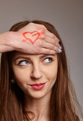 Beautiful woman with a painted heart on her hand.