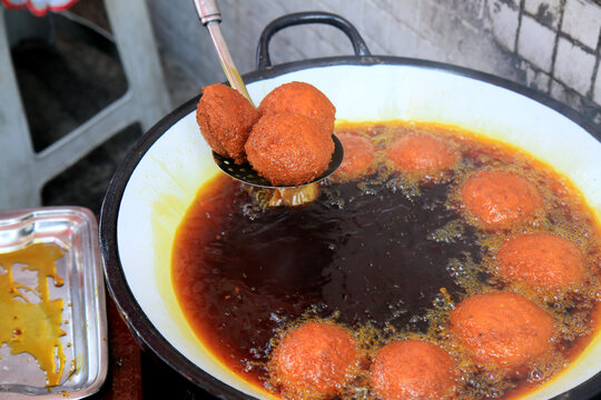 salvador, bahia, brazil - january 8, 2021: acaraje during frying in a pan with palm oil, in downtown Salvador.