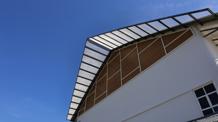Obraz premium Building roof light filtering. Modern building or architecture design for beauty and shade against sunlight on a bright sky background with copy space. Selective focus