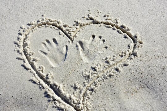 Heart In The Sand With Hand Prints On The Beach
