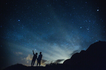 Silhouette of elderly couple on the hill.  Stargazing at Oahu island, Hawaii. Starry night sky, Milky Way galaxy astrophotography. - 403920629