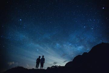 Silhouette of elderly couple on the hill.  Stargazing at Oahu island, Hawaii. Starry night sky, Milky Way galaxy astrophotography. - 403920689