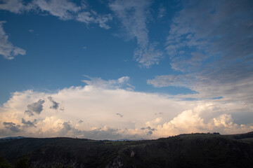 Scenic canyon view of meanders on the river Uvac, on the Zlatar Mountain with beautiful sunset with dramatic and fluffy white clouds and sky in background. Uvac is a special nature reserve in Serbia.