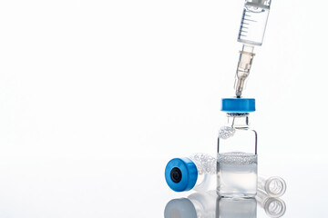 Close up on syringe with needle and vaccine injection isolated on white background - covid-19...