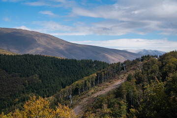 Beautiful mountain landscape of green and yellow meadows on Balkan Mountains in Serbia.Sunlit highlands and grasslands of Old mountain with distant peaks.Hiking trail for the highest peak Midzor 2169m