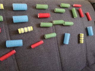 colorful Velcro curlers are scattered on the dark blue back of the sofa
