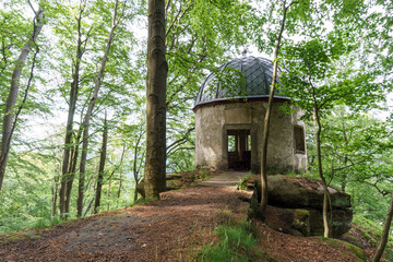 Old abandoned pavilion in german forest at cliff on rock