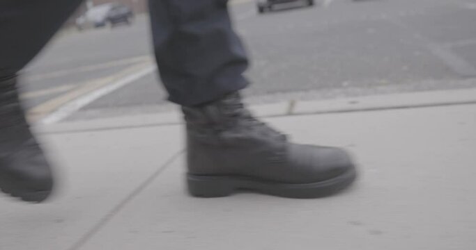 Police Officer Walking Down Parking Lot Sidewalk Ground Level 4K