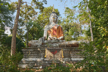 Phayao, Thailand - Dec 6, 2020: Front Meditation Buddha Statue in Green Forest and Blue Sky Background in Wat Analayo Temple