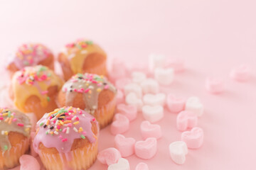 small colorful cakes with pink and white heart shaped marshmallows