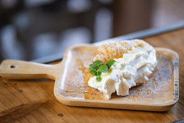 Croissant with cream serve on wooden plate