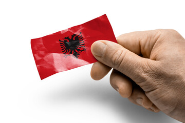 Hand holding a card with a national flag the Albania