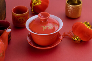 Chinese New Year of traditional tea accessories festival decorations in container mandarin oranges on red background