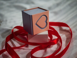 Closeup of a romantic decorative little jewelry box surrounded by red ribbons