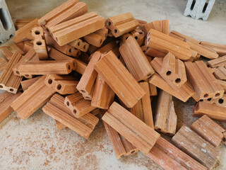Red bricks for construction work. A group of objects placed in a mess.