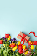 Colorful tulips and gift box with copy space. Background for womens day, 8 March Valentines day, 14 february. Flat lay style, top view, mockup, template, overhead. Greeting card, banner