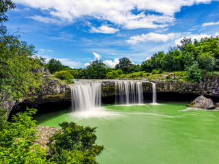 Beautiful shot of a scenic waterfall in a park on a cloudy day