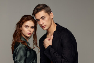 romantic man and woman in suits on gray background looking forward